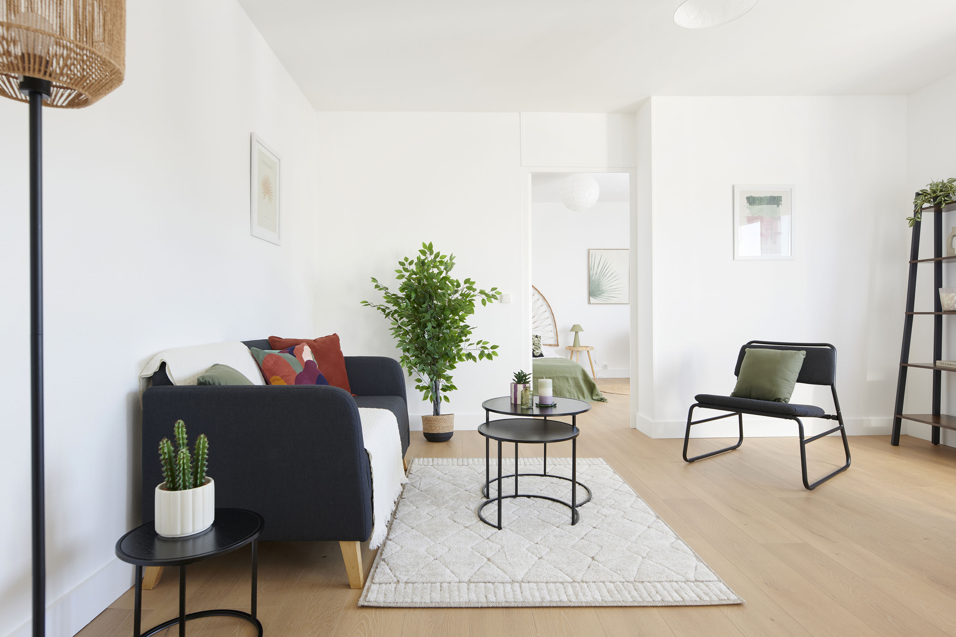 Appartement rénové par marchands de bien à Nantes et mis en ambiance pour la vente grâce au home staging par AntePostea. Salon meublé avec canapé, tapis, table basse, fauteuil , plante, déco...